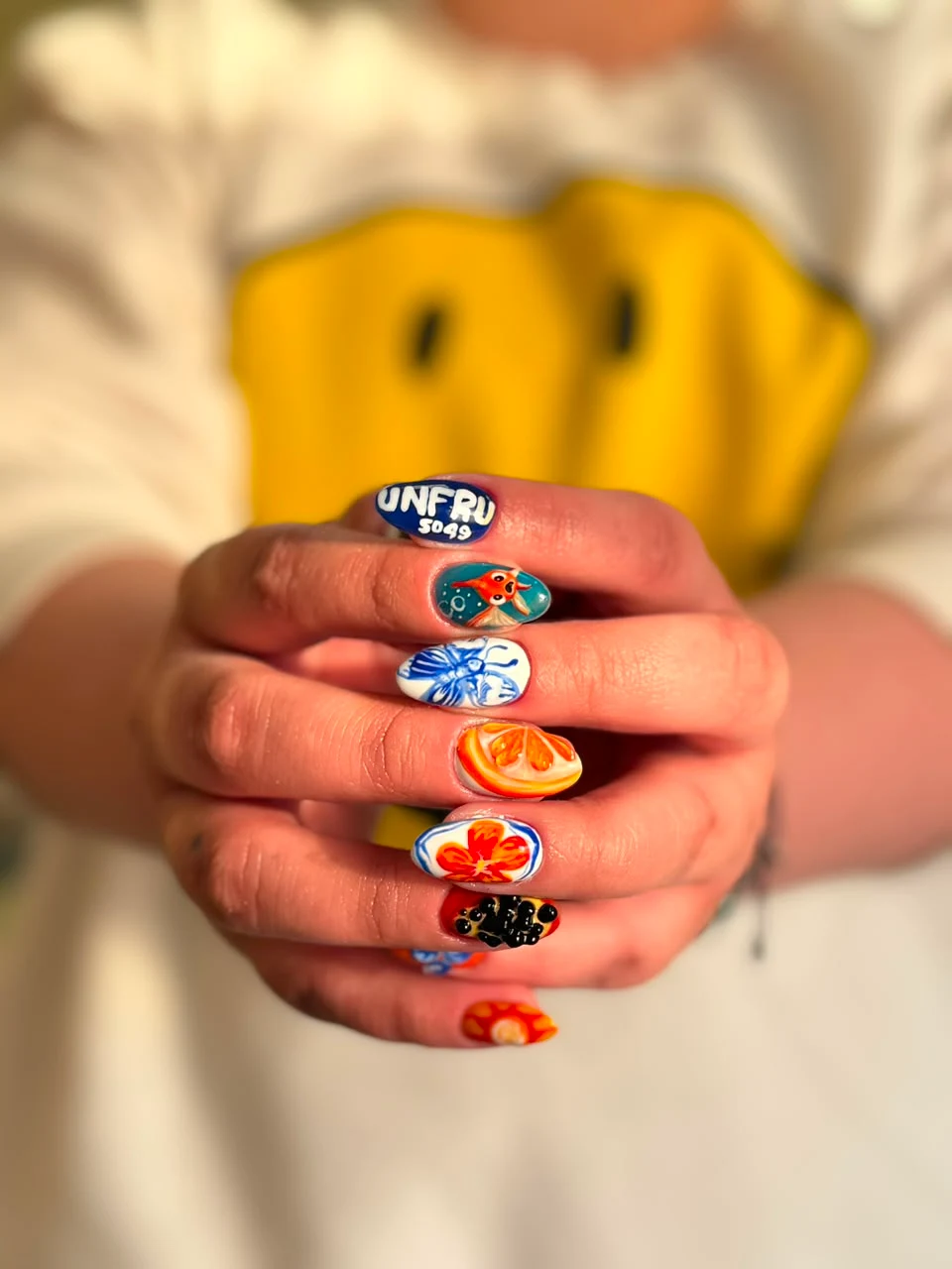 Uñas multicolor con ilustraciones y acabado brillante.