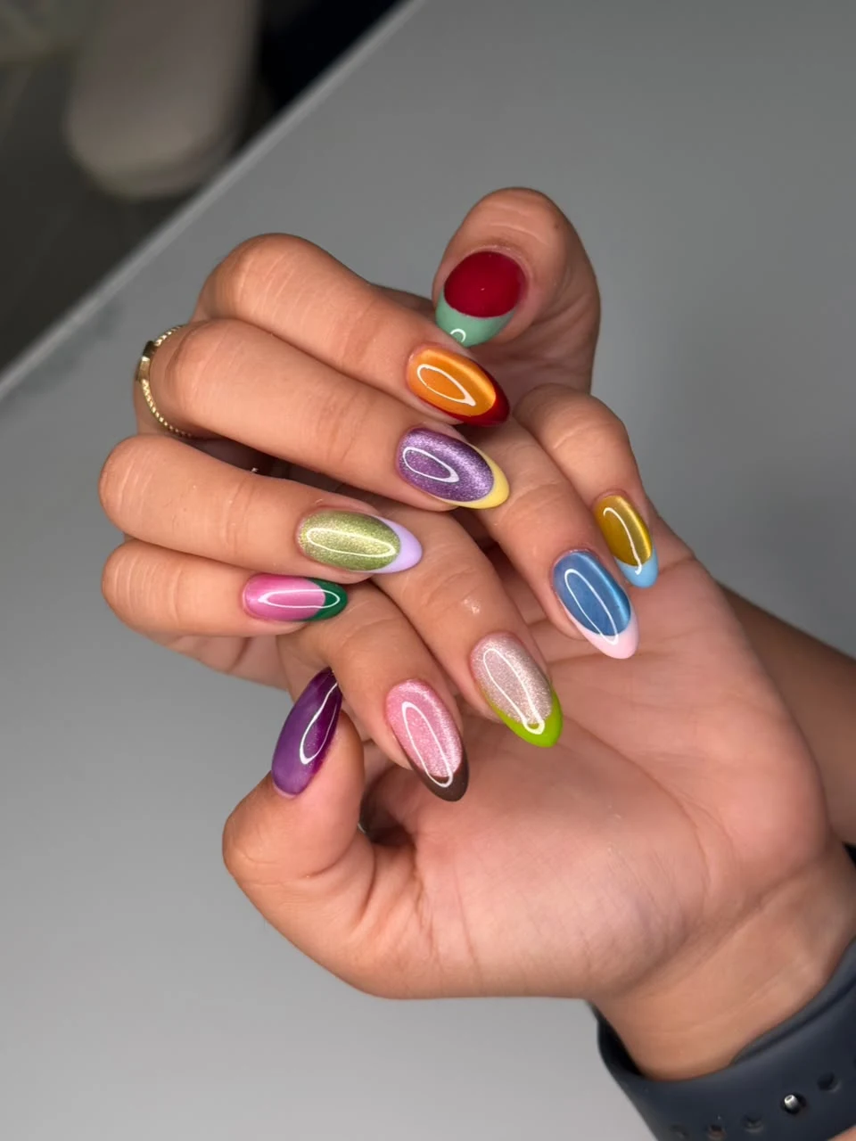 Manicura multicolor con líneas onduladas.